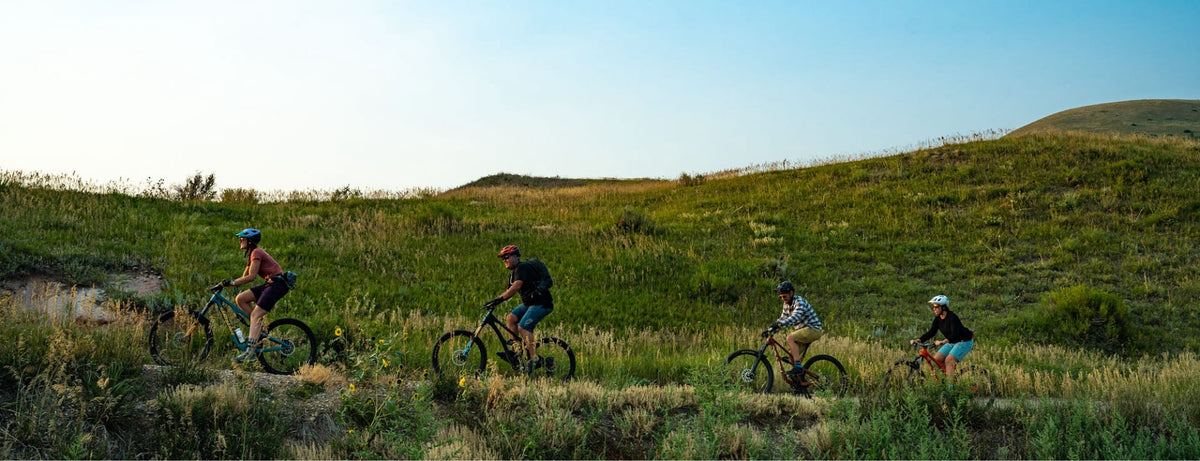 four mountain bikers on a trail